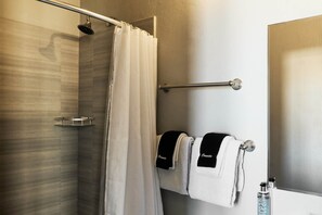 A shower area with a glass door, a towel rack with two towels, and a showerhead. - El Colonial, Superior Queen, Old San Juan (San Juan)