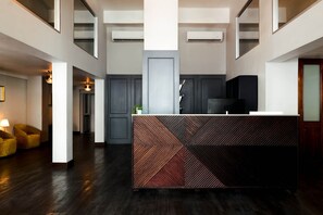 A modern reception area with a geometric patterned counter, dark wood flooring, and a minimalist design. - El Colonial, Superior Queen, Old San Juan (San Juan)