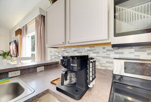 A modern kitchen with a Keurig coffee maker, a microwave, and a built-in oven. - Spacious 5BR - Games - Pool - W/D - Near Disney (Kissimmee)