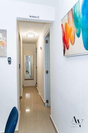 A corridor with a 'No Smoking' sign, a mirror, and a framed artwork on the wall. - New Listing (San Juan)