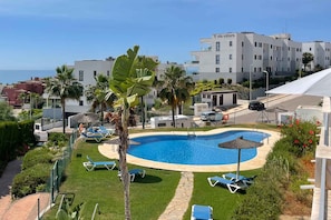 A swimming pool with lounge chairs, palm trees, and a building with 'villa selere' signage. - Apartment with Terrace and Sea Views in Casares (Casares)