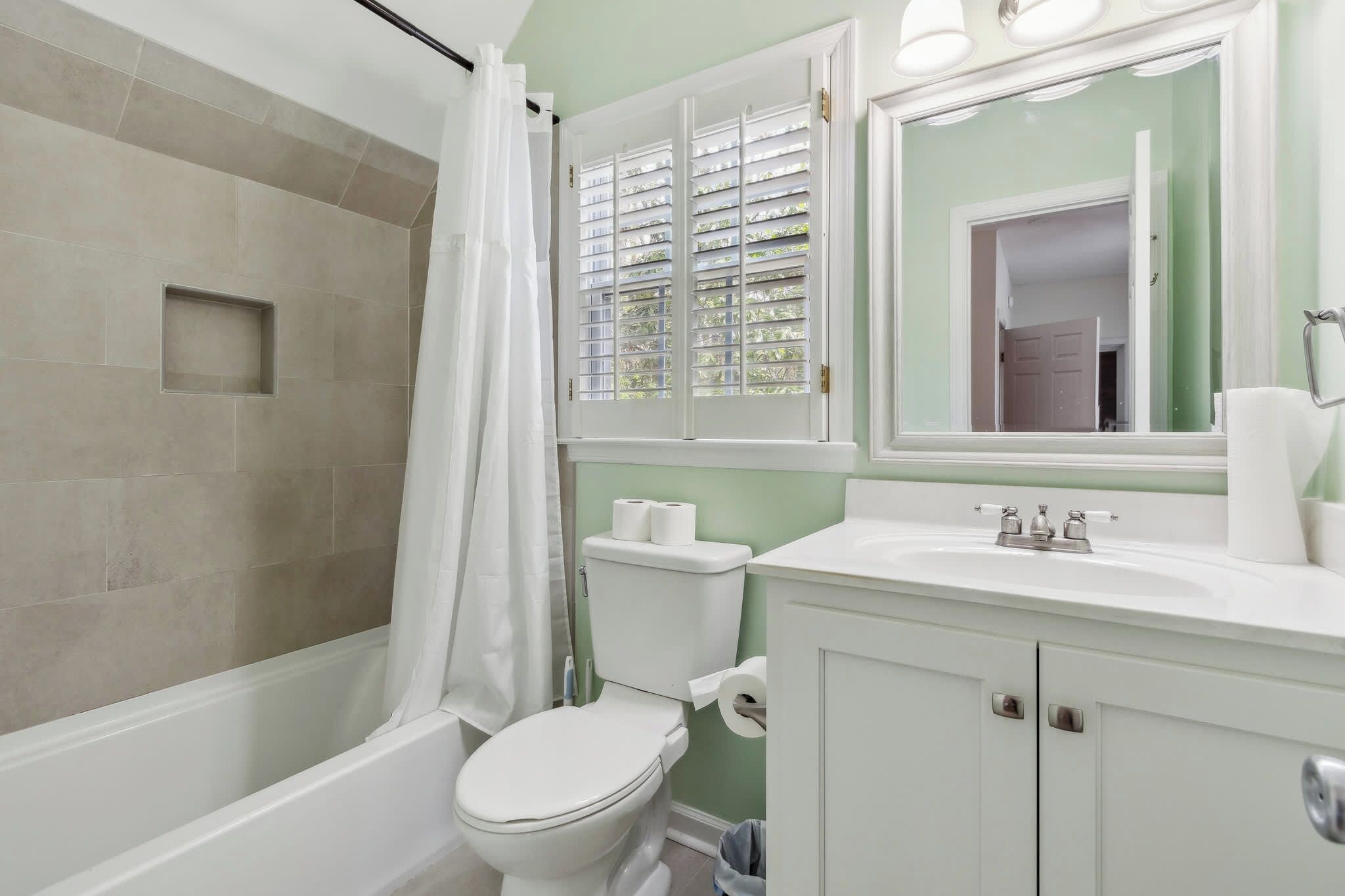 A bathroom with a bathtub, toilet, and sink.
