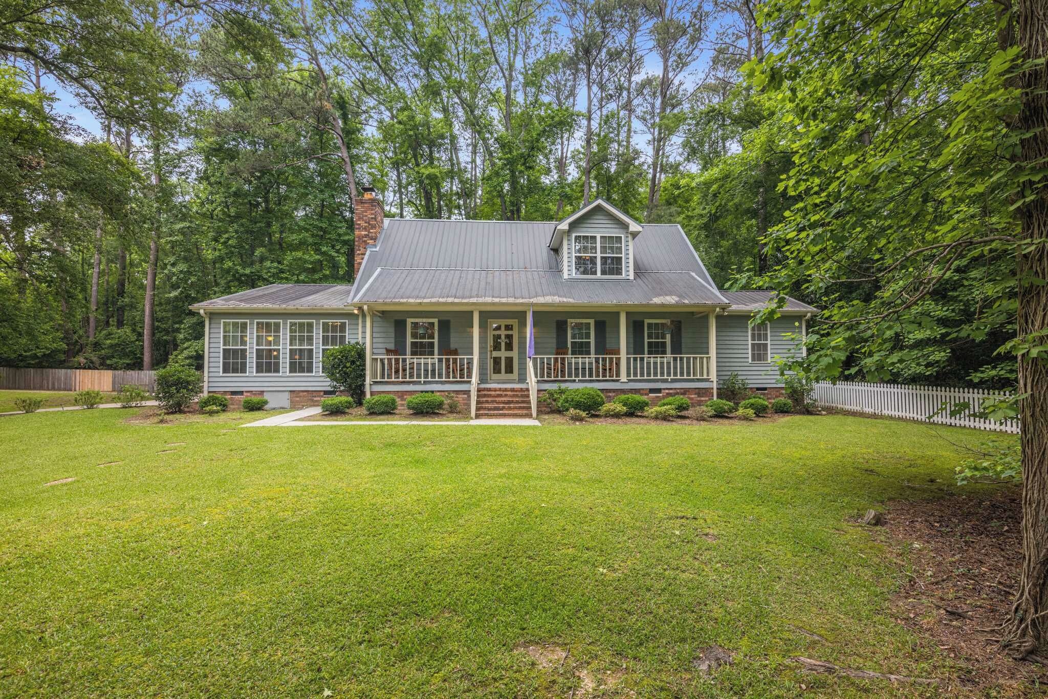 Exterior photo of the house. Discover the charm of this home, surrounded by a spacious green yard—perfect for outdoor relaxation and activities!
