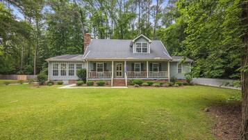Exterior photo of the house. Discover the charm of this home, surrounded by a spacious green yard—perfect for outdoor relaxation and activities!
