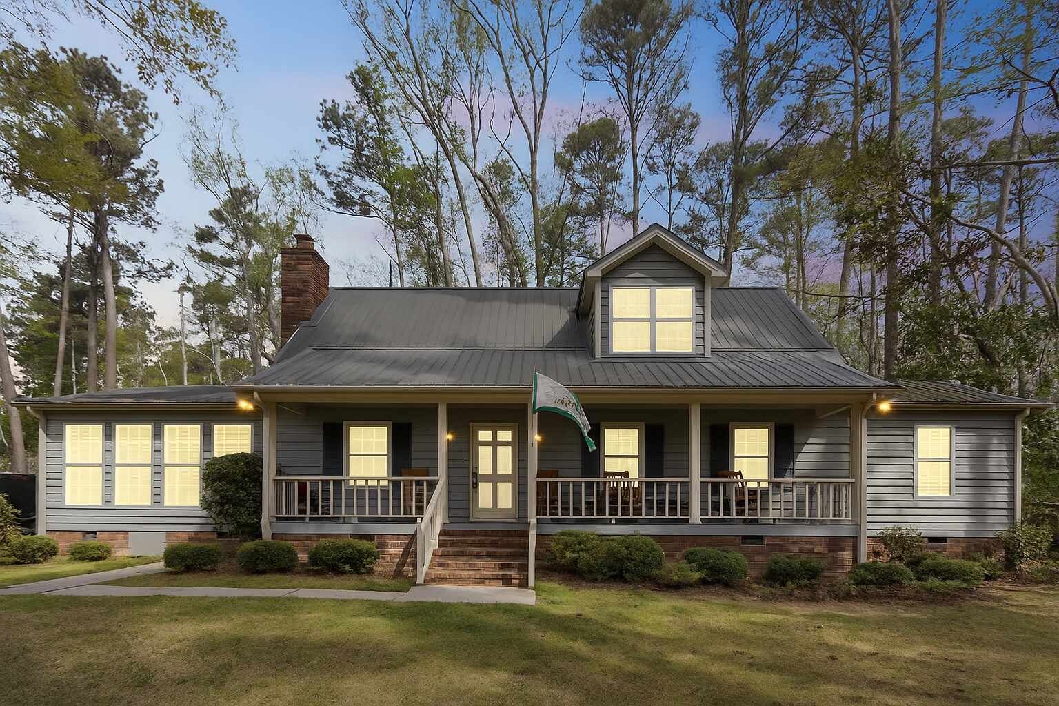 A two-story house with a front porch, a chimney, and a well-maintained lawn.