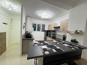 Ett modernt kök med en central köksö, inbyggda skåp och ett fönster.