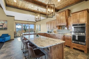 A spacious kitchen with a large island, wooden cabinets, and a built-in oven. - Star of the Summit: 5 bedrooms, Private Indoor Pool, Stunning Views (Sevierville)