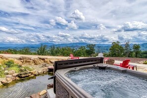 A hot tub with a view of mountains, surrounded by outdoor seating and a natural landscape. - Tennessee Whiskey: Sweeping Views, Indoor Pool, 9-hole Golf (Sevierville)