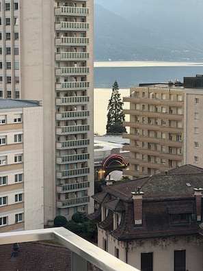 Un palazzo alto con diversi balconi, vista sul mare e un edificio tradizionale con tetto in tegole.