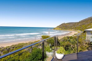 Un balcon avec vue sur une plage et l’océan.