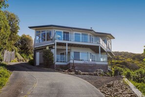 Un bâtiment à deux étages doté d’un balcon, d’une allée et d’une enseigne sur laquelle on peut lire : « Vue imprenable sur la mer ».
