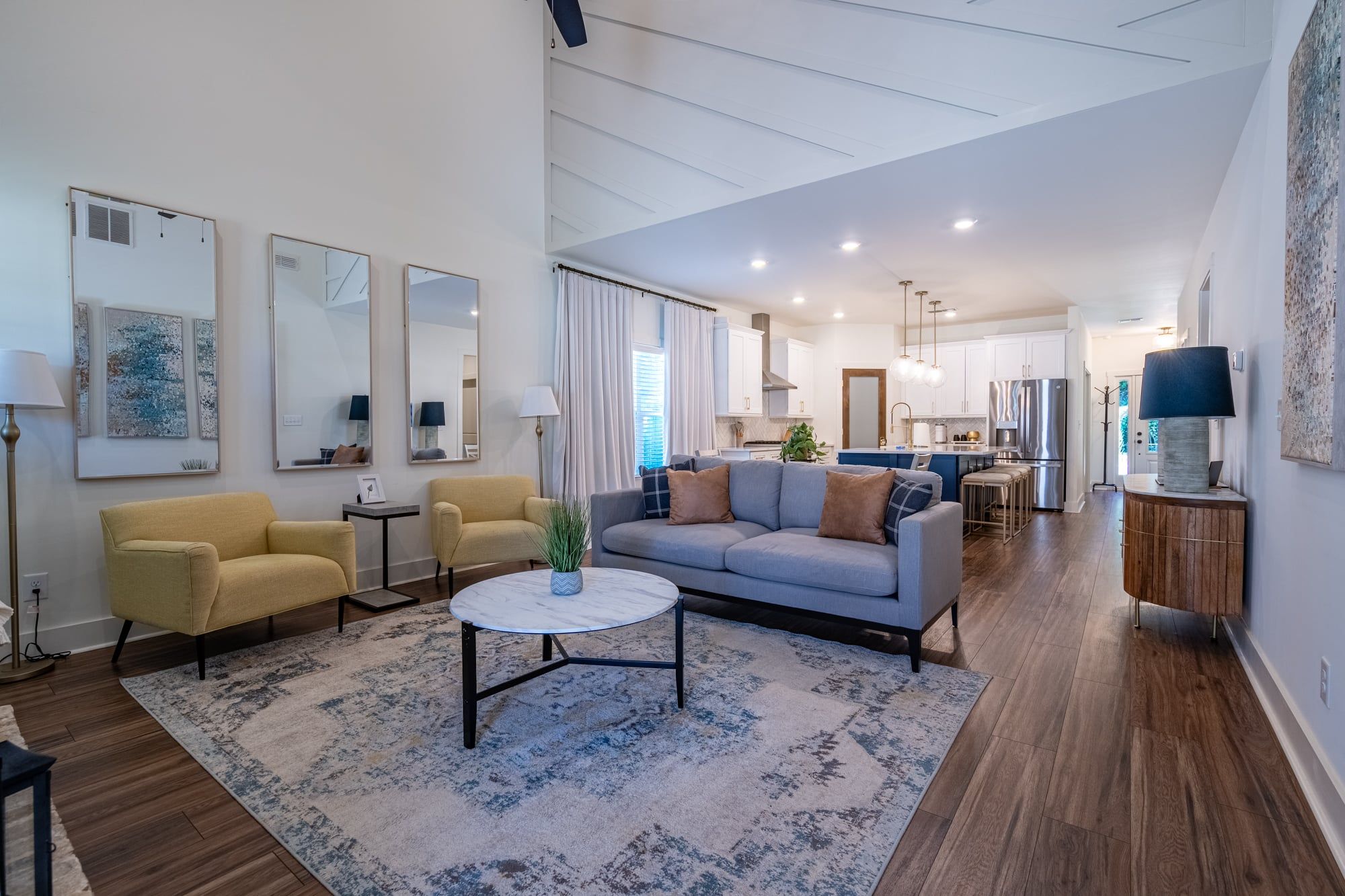 A modern living room with a sofa, armchairs, a coffee table, and artwork on the walls.
