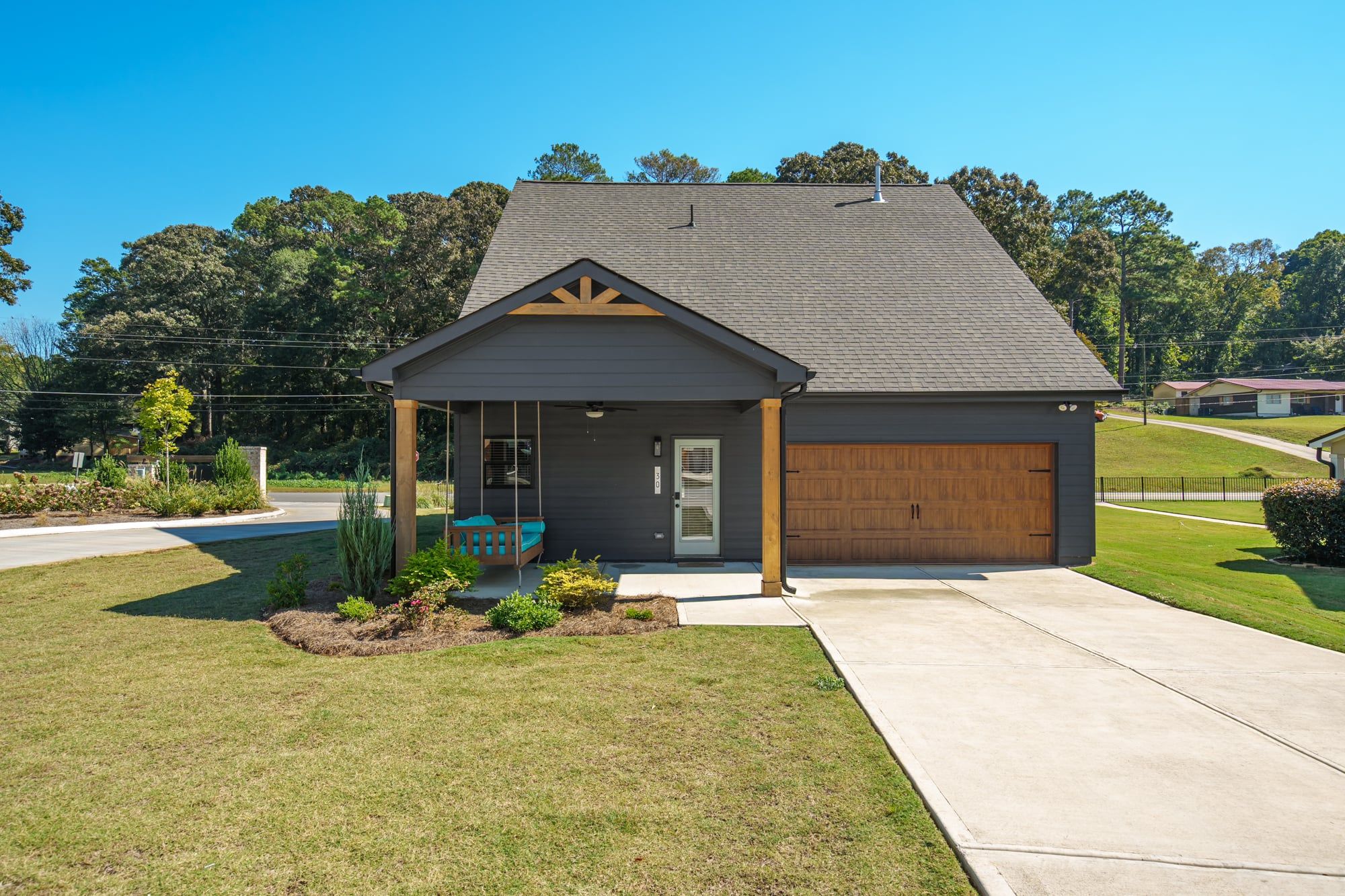 A single-story house with a covered porch, a garage, and a well-maintained lawn.
