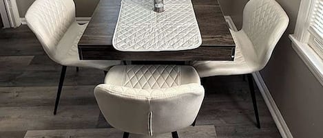 A dining area with a table, four chairs, and a salt shaker.