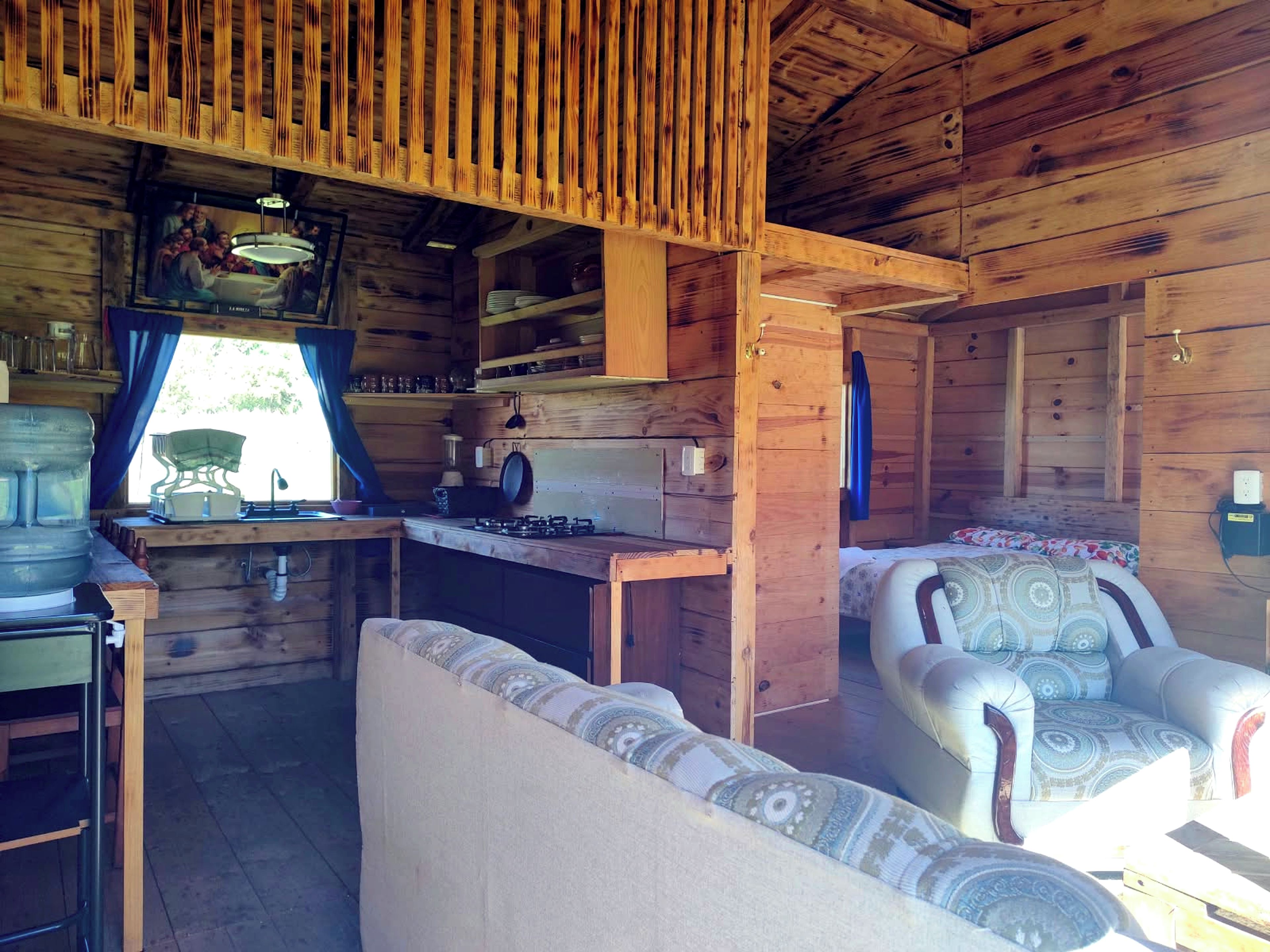 A cabin interior with a kitchenette, a sofa, and a dining table.