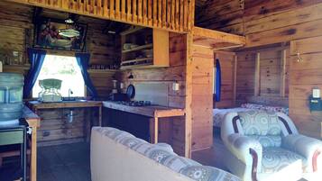 A cabin interior with a kitchenette, a sofa, and a dining table.