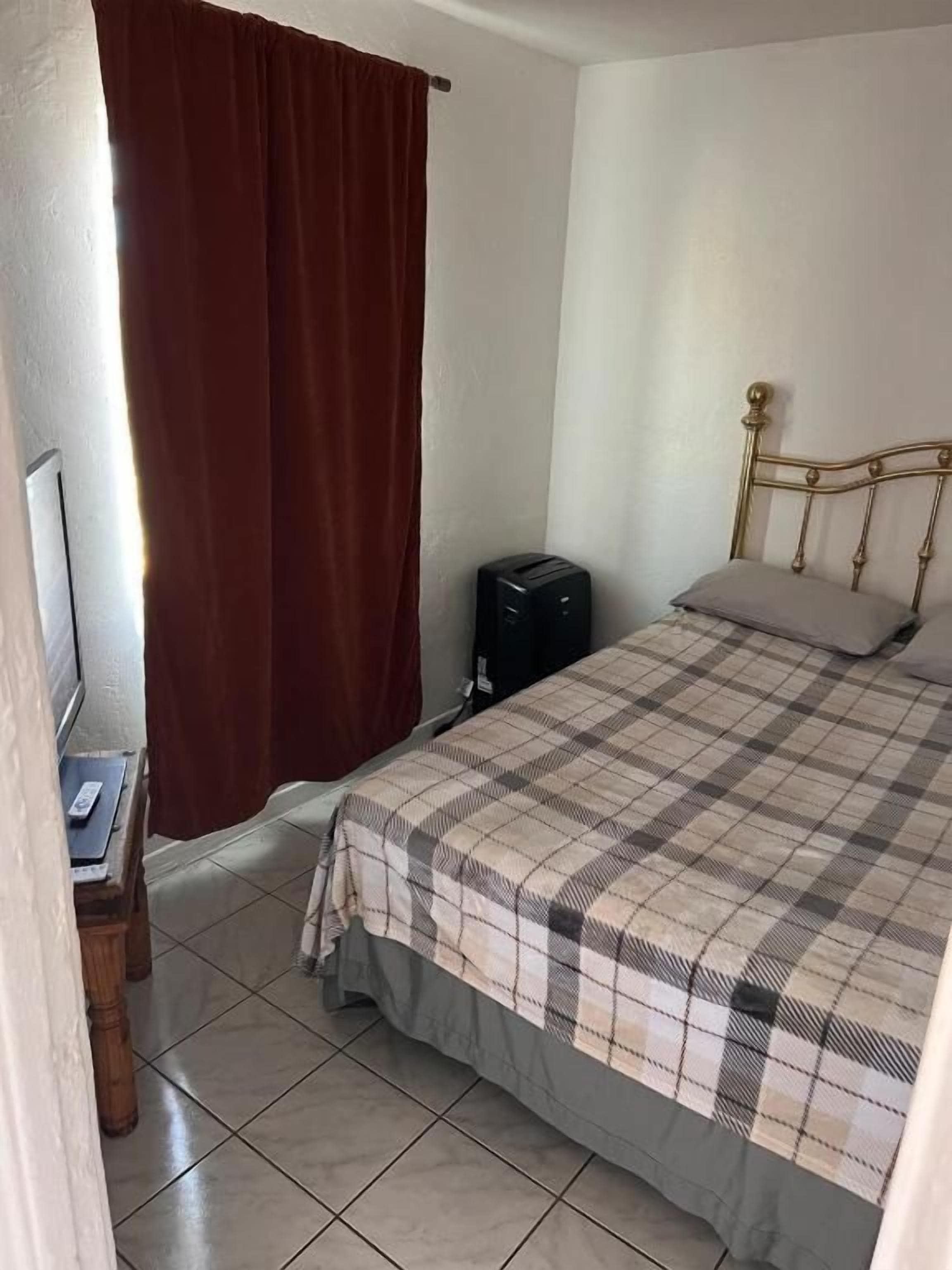 Un dormitorio con cama, escritorio y televisión.