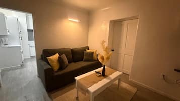 Ein Wohnzimmer mit einer Couch, einem Couchtisch und einer Tür.