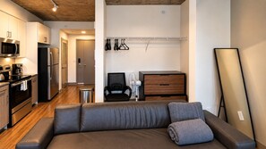 Un espace de vie moderne comprenant un canapé, un coin repas et une kitchenette.