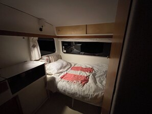 Un dormitorio pequeño con una cama individual, un escritorio y una ventana.