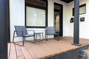 A wooden deck with two black chairs and a small table. - The University District Hideaway | Spacious 3BR (Salt Lake City)