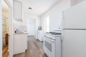 A kitchen with white appliances, a stove, and a refrigerator. - The University District Hideaway | Spacious 3BR (Salt Lake City)