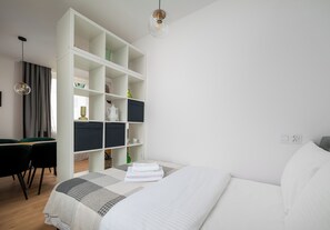 A modern bedroom with a bed, a desk, and a wardrobe. - Metro Politechnika Central Apartment (Warszawa)