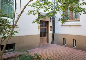 Ein Gebäudeeingang mit Tür, Fenster und einem Pflasterweg.