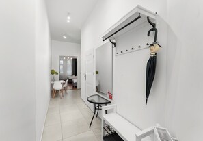 Une salle de bain moderne avec un lavabo blanc, un miroir et un porte-serviettes.
