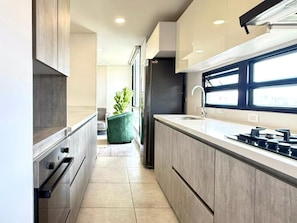 A modern kitchen with a large island, built-in appliances, and a window providing natural light. - New Listing (Bogotá)