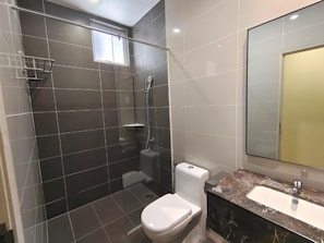 Une salle de bain avec douche, toilettes et lavabo.