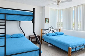 A room with bunk beds, a small bedside table, a ceiling fan, and a window with blinds. - New Listing (Tonsupa)