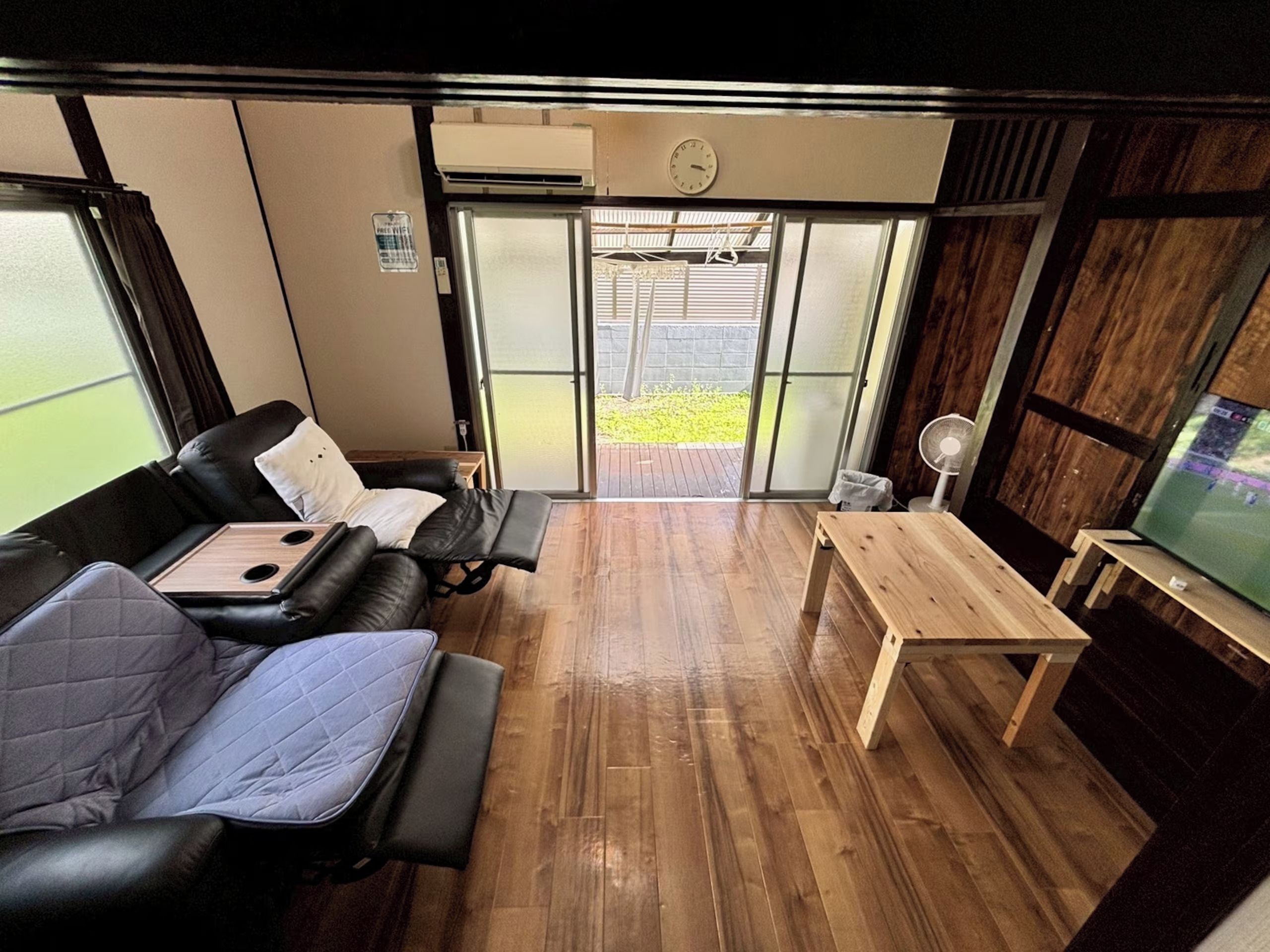 A room with a sofa, a small table, and a television.