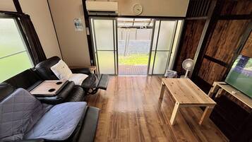 A room with a sofa, a small table, and a television.