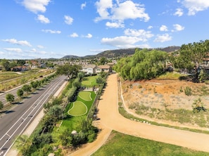 Zona residencial com estrada, áreas verdes e casas.