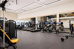 Ein Fitnessstudio mit unterschiedlichen Trainingsgeräten, darunter Laufbänder und Kraftgeräte.