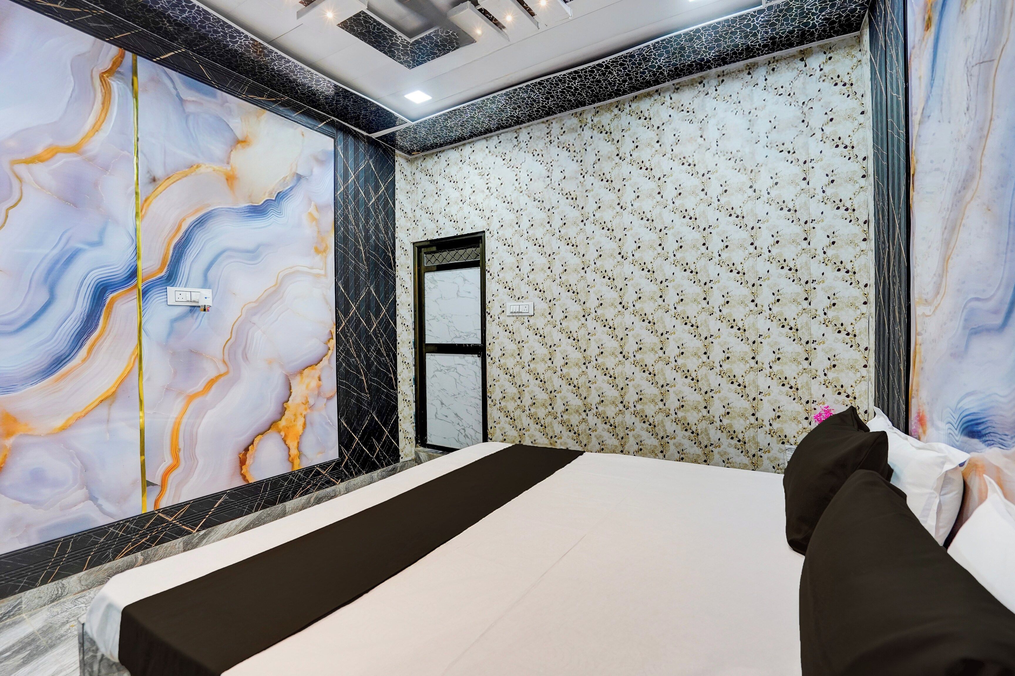 Una habitación de hotel con una cama, un espejo y un papel tapiz estampado.
