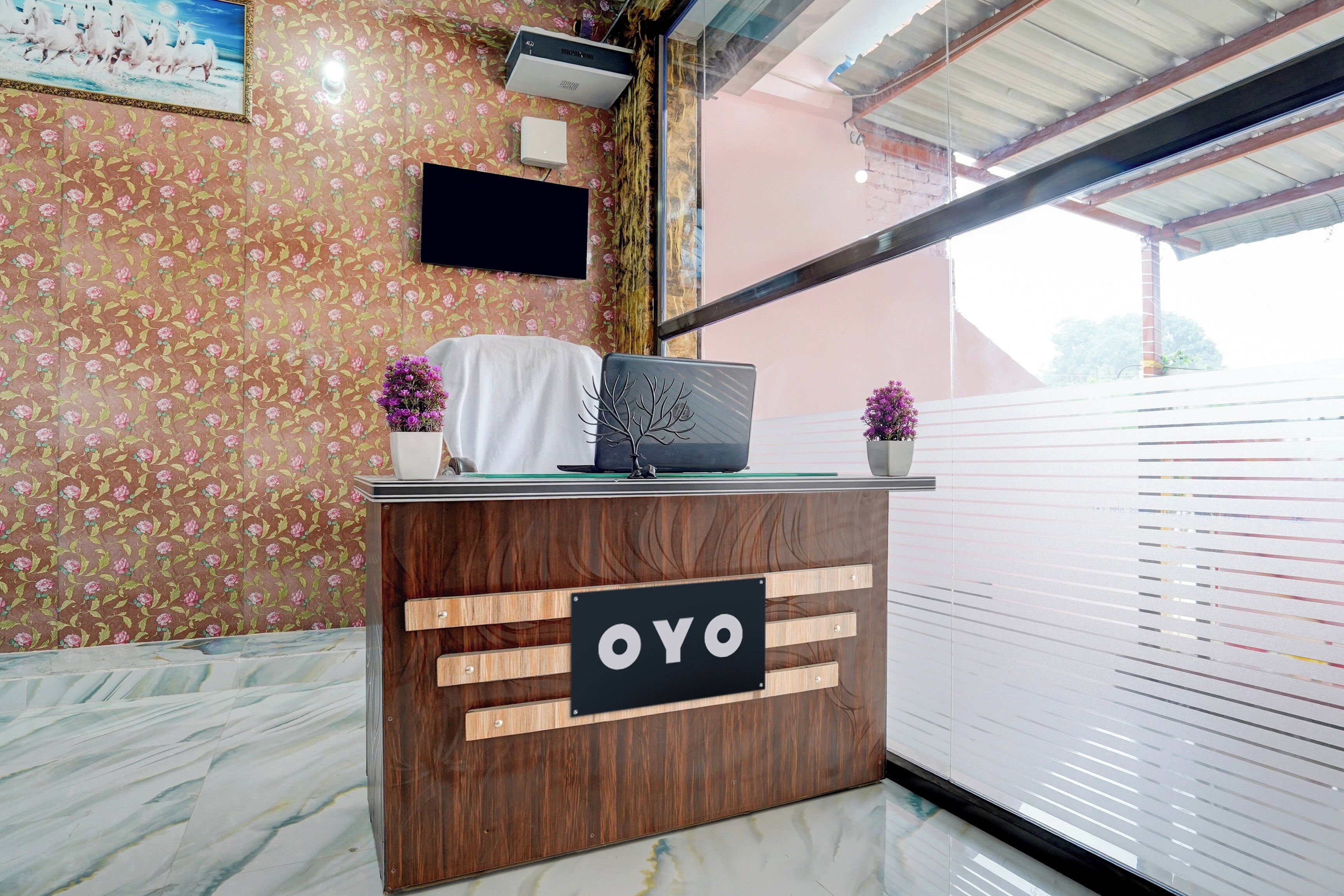 Un comptoir d’accueil avec un revêtement en bois et une enseigne indiquant « OYO ».