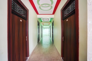 Un pasillo con puertas de madera, con los números 102 y 103, que conduce a una habitación luminosa.