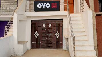 Entrada de un hotel con un gran cartel que dice 'OYO Hotel Royal Star and Restaurant'.
