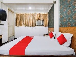 A hotel room with a bed, a television, a telephone, and a window with curtains. - Hotel O Raj Palace (Ahmedabad)