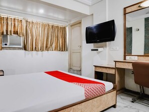 A hotel room with a bed, a desk, a television, and a mirror. - Hotel O Raj Palace (Ahmedabad)