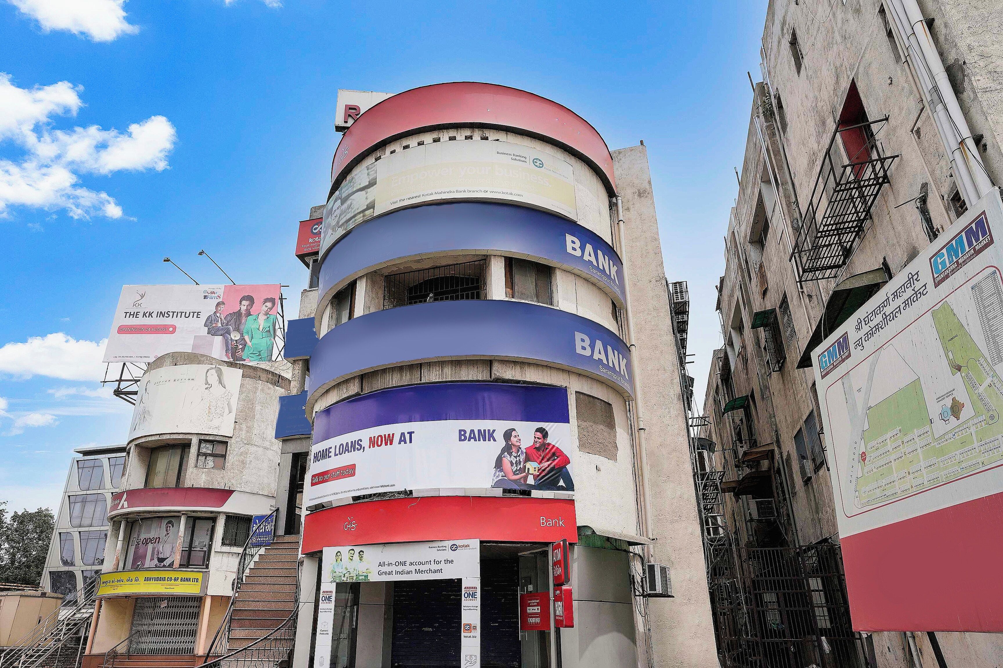 A multi-story building with commercial signage, including a bank and a cinema.