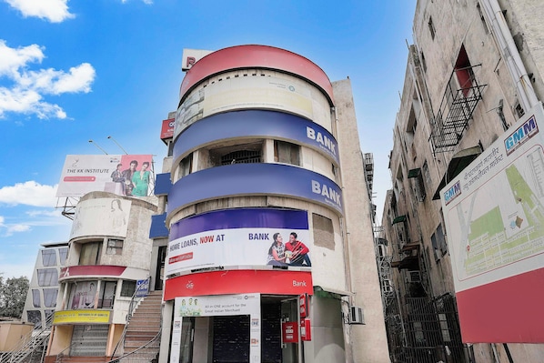 A multi-story building with commercial signage, including a bank and a cinema. - Hotel O Raj Palace (Ahmedabad)