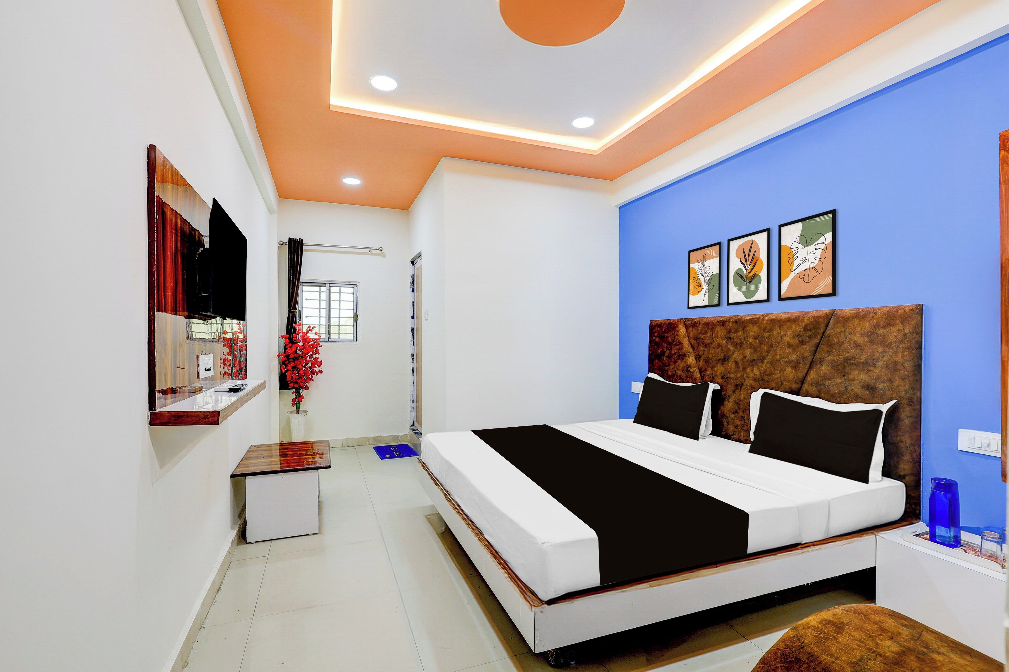 Un dormitorio moderno con una cama grande, una mesita de noche, un espejo y una pared de acento azul.