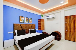 A modern bedroom with a bed, a wardrobe, and an air conditioning unit. - Hotel O by OYO Shaligram (Ahmedabad)