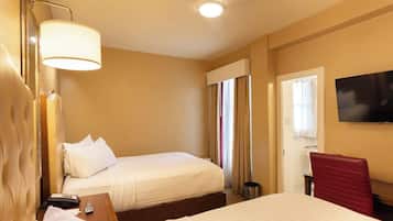 A hotel room with two beds, a TV, a desk, and a chair.