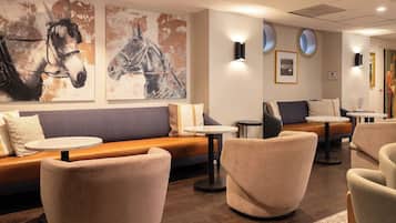 Ein moderner Lounge-Bereich mit Sofas, Sesseln und einem Couchtisch.