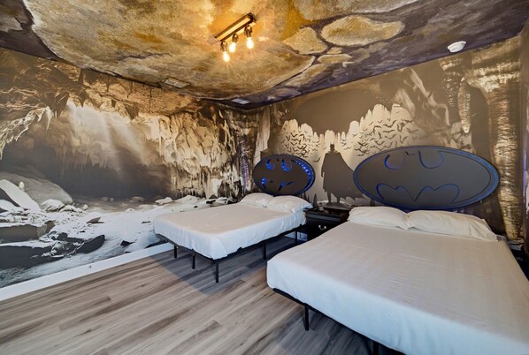 A room with two beds, a stone wall mural, and a ceiling light fixture. - 9BR pool & spa | Train bunks + Donkey Kong games (Kissimmee)