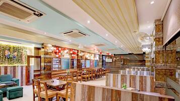 A restaurant interior with wooden furniture, a bar area, and decorative balloons.